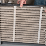 Technician changing a dirty furnace air filter to improve efficiency