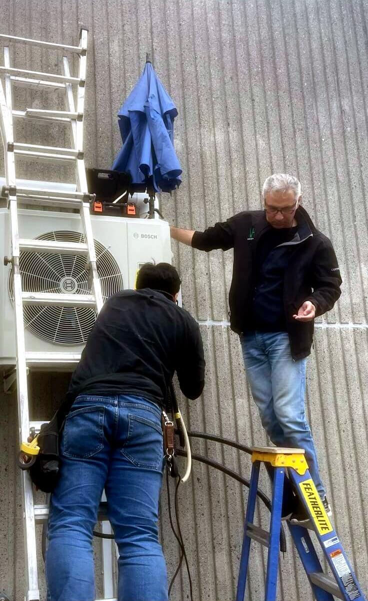 HVAC services Surrey: Vanheat Services technicians at work on a Bosch outdoor heat pump and air conditioning condenser unit